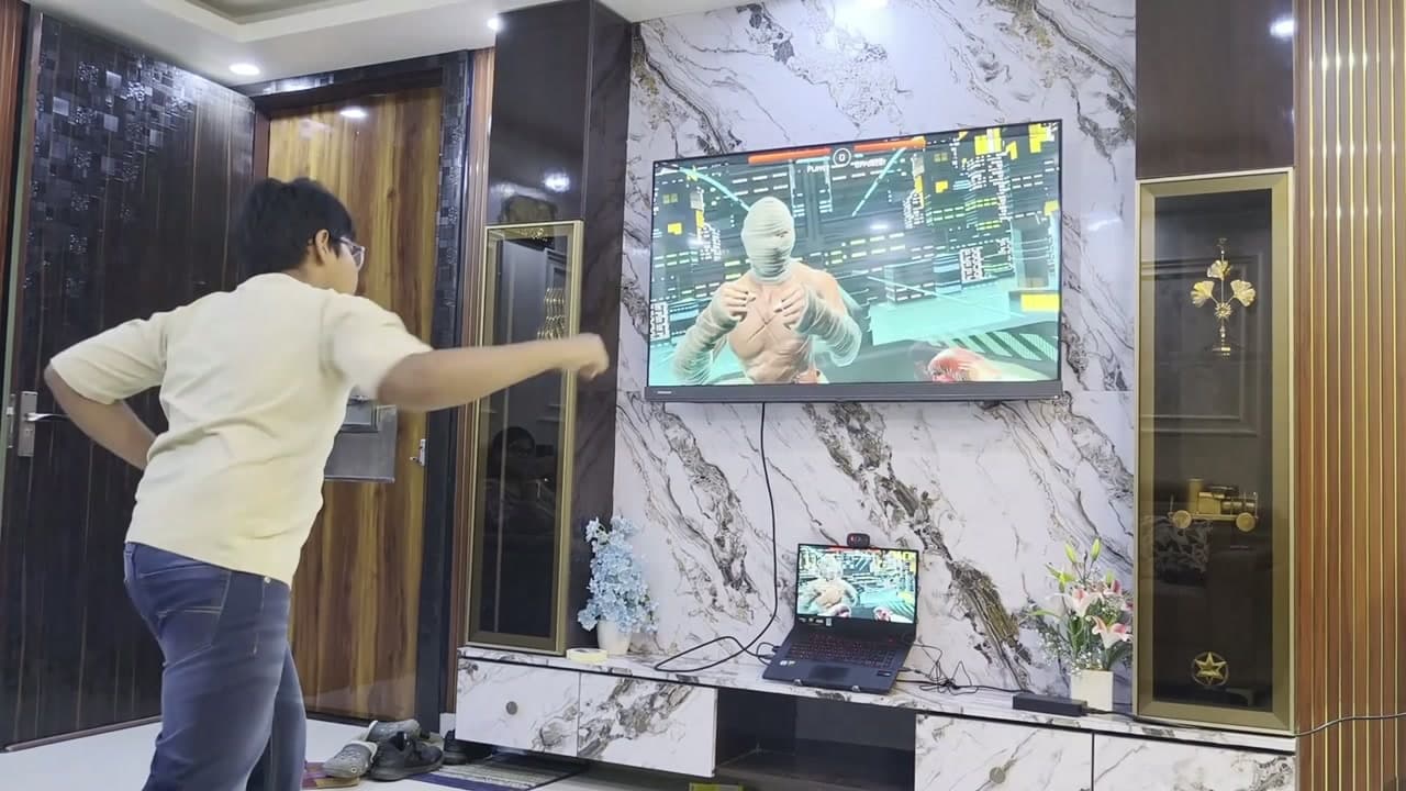 A boy throwing a punch at a boxing game on the TV