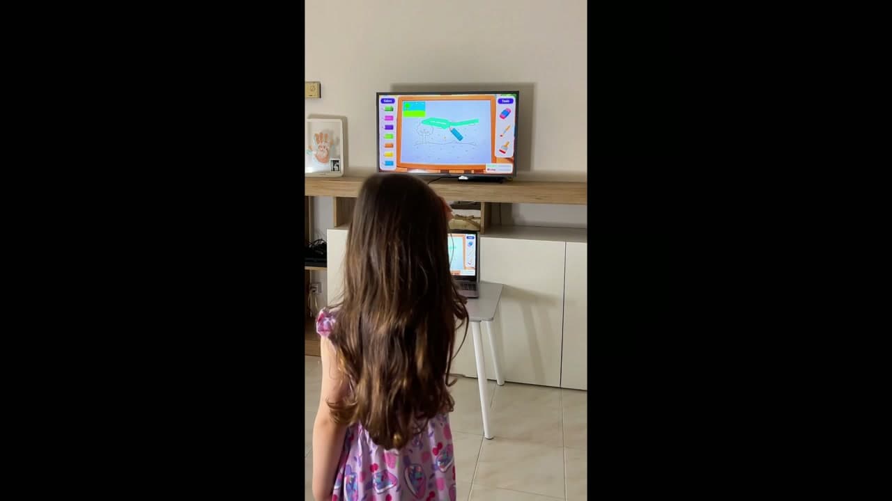 A girl painting in the air while playing Magic Easel