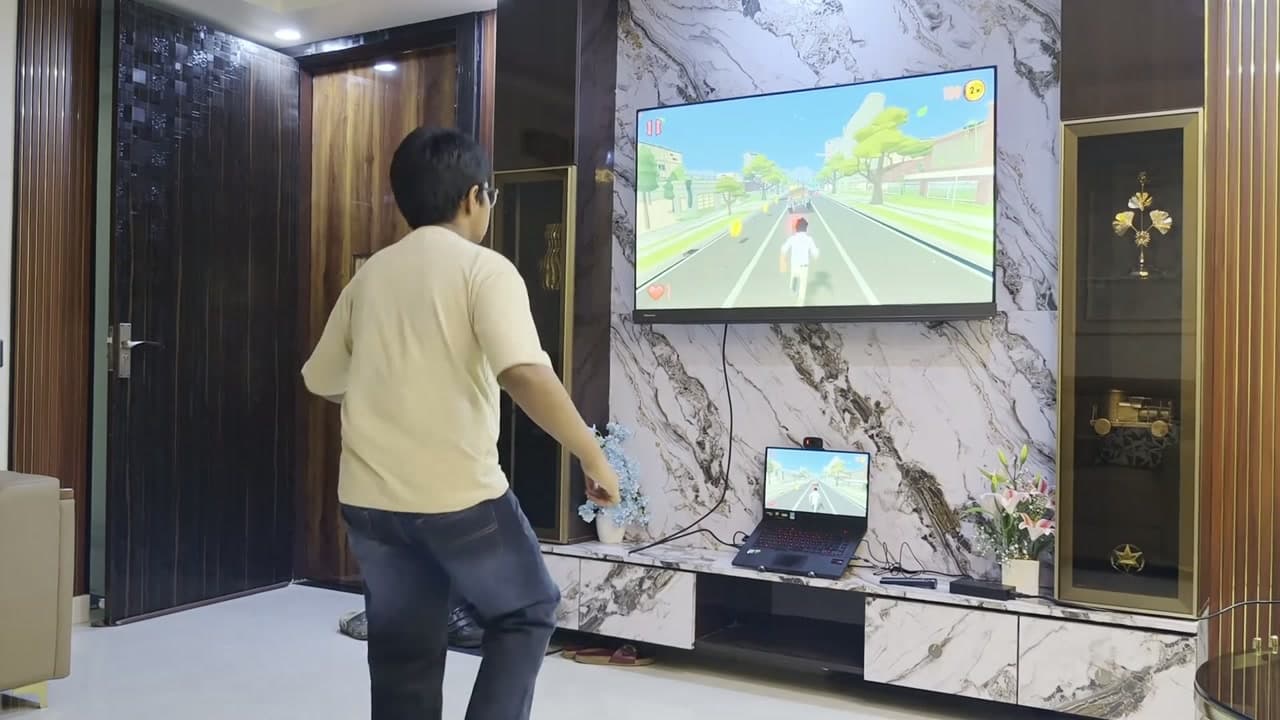 A boy standing a few steps back from the TV, playing a running game
